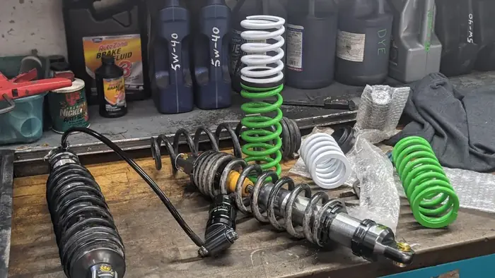 Aftermarket UTV shocks and springs on the bench before a suspension install at TMT Offroad in Williston, FL